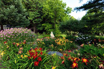 The Bange daylily garden spreads over three quarters of an acre and includes a water lily pond, a mix of evergreens, sculptures, and stonework.